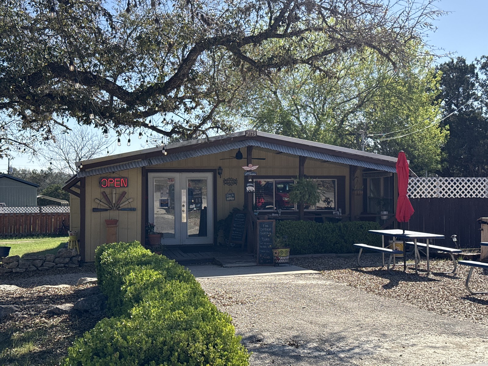 D'Vine House Bistro exterior with OPEN sign, string lights, and shaded patio under a live oak tree