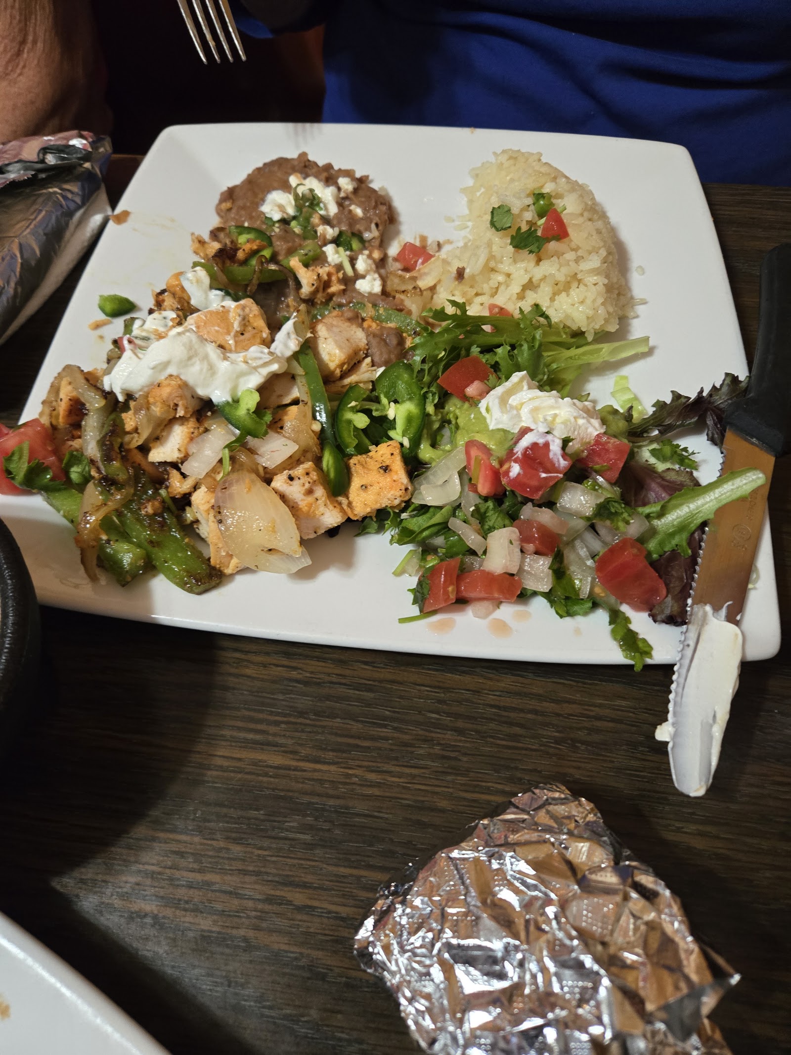Chicken fajita plate with rice, beans, guacamole, and pico de gallo